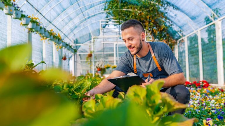 Shot of a happy male florist in his garden center managing crops and performing cost benefit analysis on production